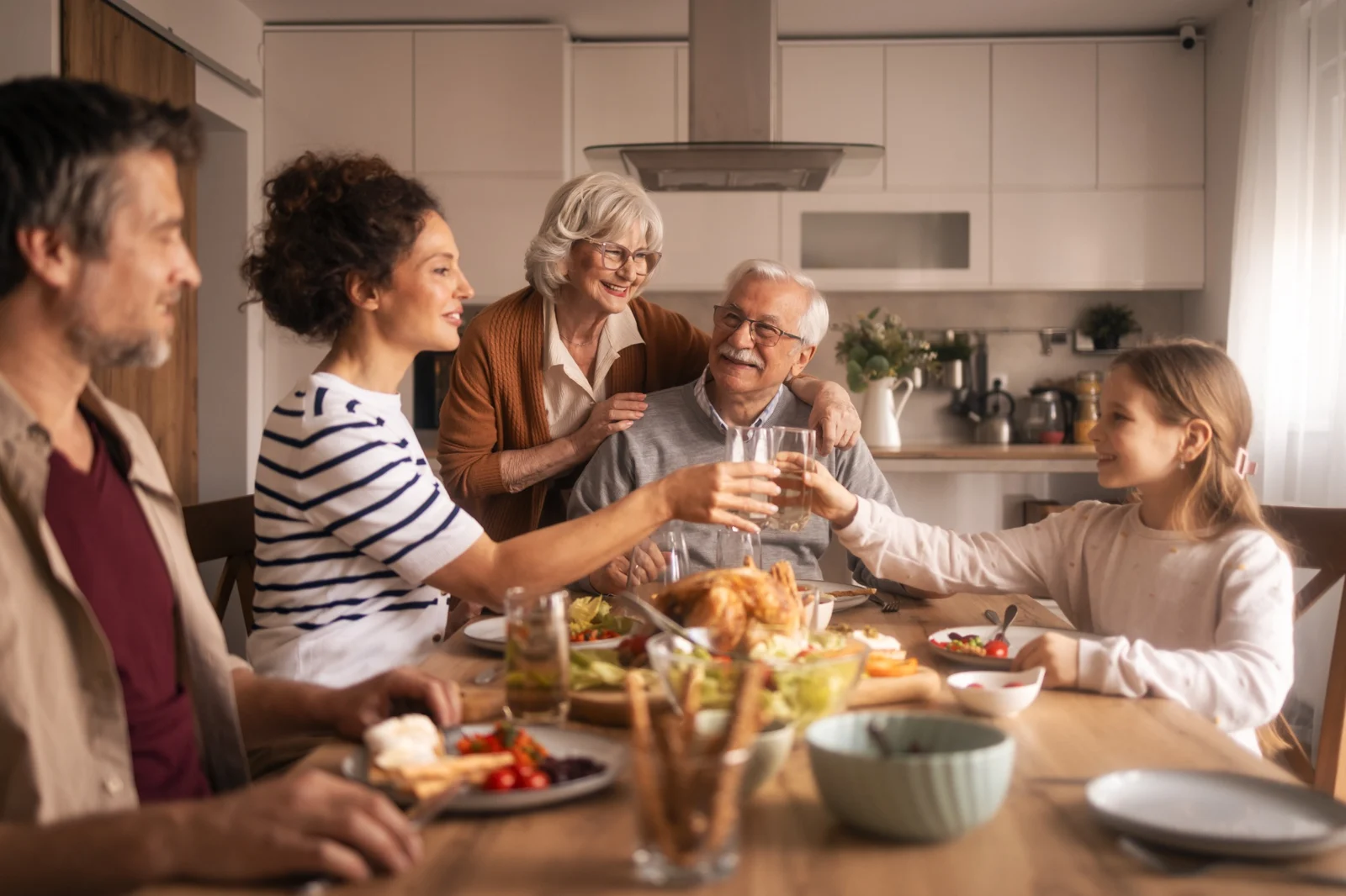 Drei Generationen einer Familie genießen ein gemeinsames Essen zu Hause